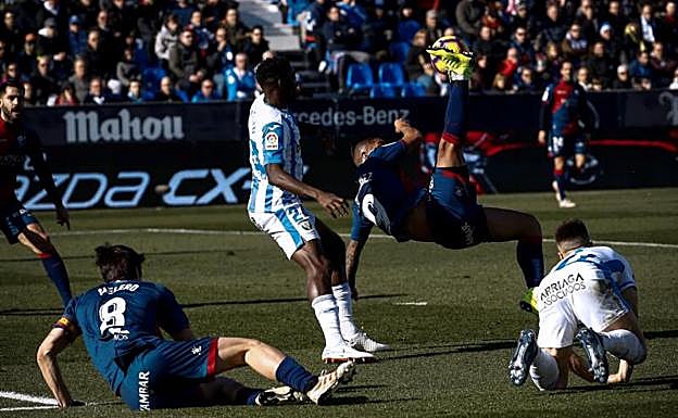 El delantero del Huesca, Cucho Hernández, golpea la pelota de forma acrobática.