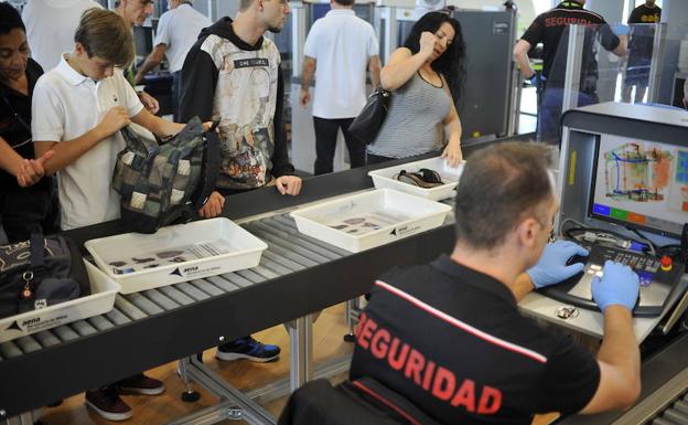 Pasajeros y agentes de seguridad en el control de seguridad del Aeropuerto de Bilbao. 