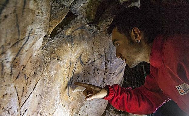 Un hombre examina las marcas localizadas en Chufín.