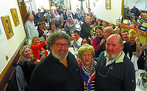 Tibur y Jon, junto a su amatxo Mari Carmen Lucas, mientras los comensales brindan por ellos. 