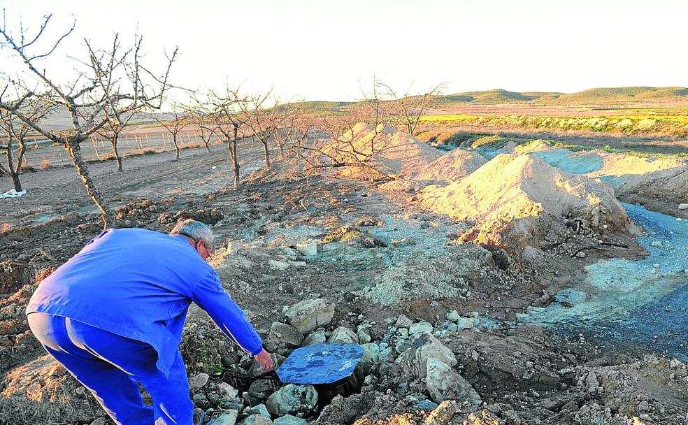 Un agricultor revisa la tapa de un pozo en una finca agrícola de la Región de Murcia.