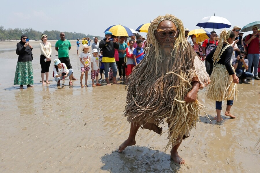 Los miembros de la tribu de Mah Meri, indígenas de Malasia, usan una máscara tradicional antes de iniciar el ritual «Puja Pantai», como gesto de agradecimiento que reza a los espíritus de los mares en Pulau Carey, a las afueras de Kuala Lumpur. 