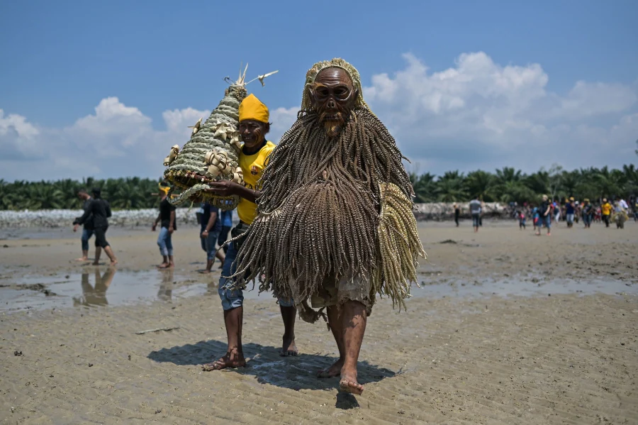 Los miembros de la tribu de Mah Meri, indígenas de Malasia, usan una máscara tradicional antes de iniciar el ritual «Puja Pantai», como gesto de agradecimiento que reza a los espíritus de los mares en Pulau Carey, a las afueras de Kuala Lumpur. 