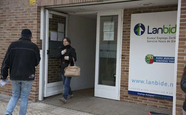 Una mujer sale y un hombre entra en la oficina de Lanbide de Donostia. 