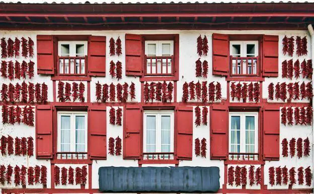 Espelette es el pueblo conocido por sus pimientos rojos secos que, como recoge la imagen, lucen en las fachadas de sus casas.