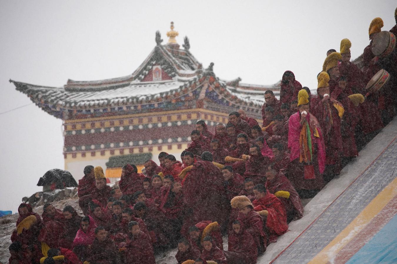 El frío y la nieve no impidió que los monjes tibetanos asistieran a una ceremonia en el Langmu Lamasery durante el 'Sunbathing Buddha Festival', el pasado domingo en la Prefectura Autónoma Tibetana de Gannan, provincia de Gansu, China.