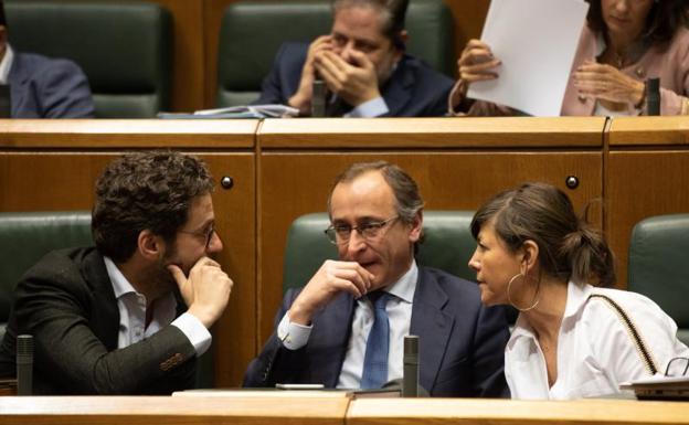 El presidente del PP del País Vasco, Alfonso Alonso (c), conversa en su escaño con los parlamentarios de su partido Borja Semper y Nerea Llanos, el pasado viernes durante el pleno de control del Parlamento Vasco. 