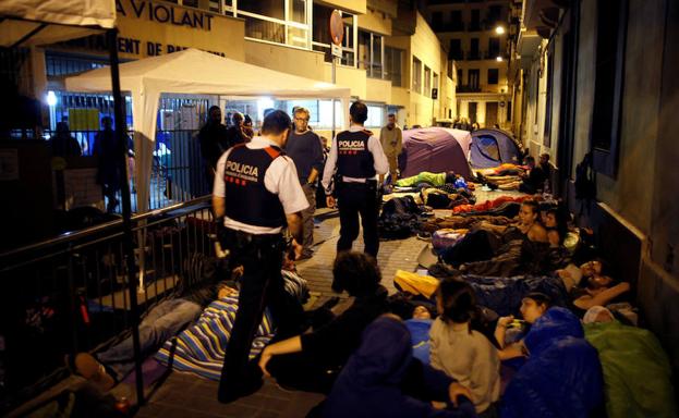 Una pareja de mossos accede en la madrugada del 1-O a un colegio de Barcelona donde decenas de personas montaban guardia.