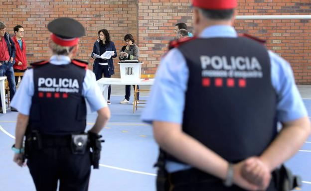 Una pareja de mossos contempla la votación del 1-O.