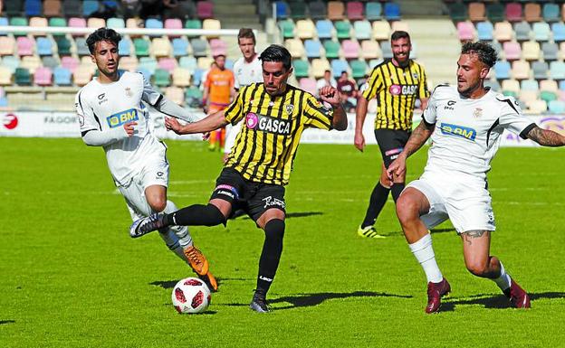 Eizmendi y Sola tratan de frenar a un jugador del Barakaldo. 