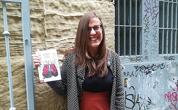 Aintzane Usandizaga, Pili Aguadoren azala eta marrazkiak dituen liburua eskuetan duela.