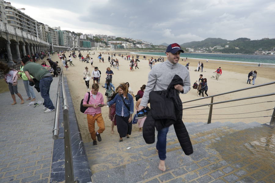 Turistas abandonan la playa de La Concha. 