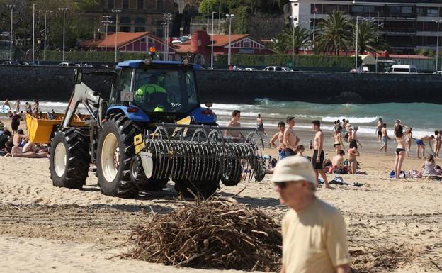 Imagen principal - Un tractor con cribadora limpia la playa de Ondarreta. Abajo, un camión Rovac para despejar sumideros y una barredora. 