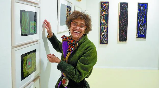 Marta Cárdenas sonríe junto a sus obras expuestas.