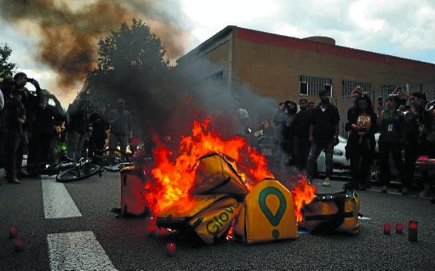 Mochilas de Glovo ardiendo en mitad de la carretera. 