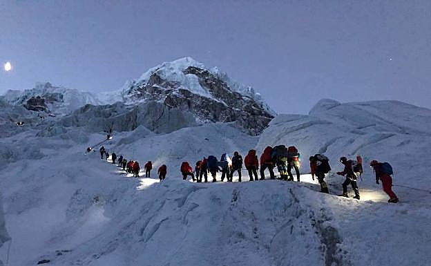 Un grupo de clientes y sherpas asciende camino de los campos de altura.