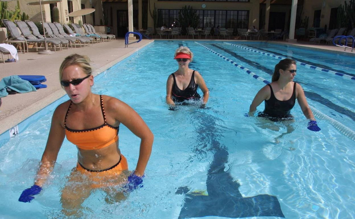 Tres mujeres realizan un ejercicio en el agua. 