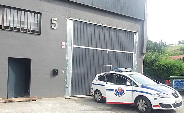 Un coche patrulla custodiaba ayer al empresa del acusado en Lazkao. 