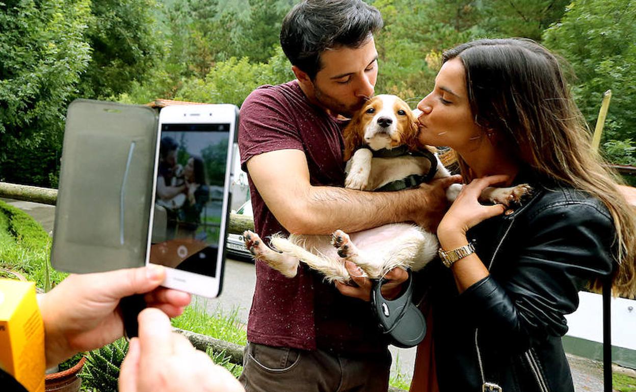 Cristian y Leire besan a 'Julieta', una cocker spaniel de cuatro meses que acaban de adoptar en la Protectora de Plantas y Animales de Gipuzkoa.