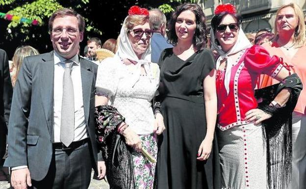 La presidenta Díaz Ayuso y el alcalde de Madrid, José Luis Martínez Almeida, posan con dos asistentes a las fiestas de La Paloma. 