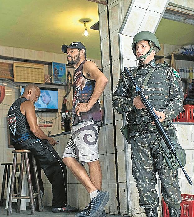 Imagen principal - Postales.  Soldados brasileños patrullando por Rocinha. Un niño jugando al balón. Vista de la favela. 