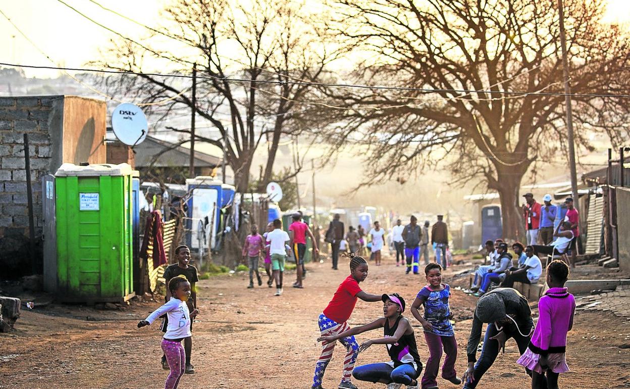 Niños juegan al atardecer en las calles de la barriadade Kliptown, en Soweto. 