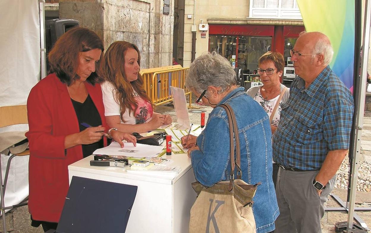 Trámites. Tres ciudadanos en el stand de 'Mugipuzkoa' itinerante que ayer estuvo en Arrasate.