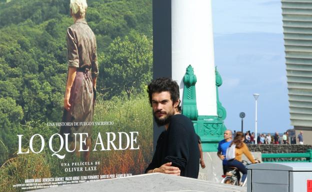 El cineasta gallego Oliver Laxe, ayer en el Kursaal junto al cartel de su último largometraje. 