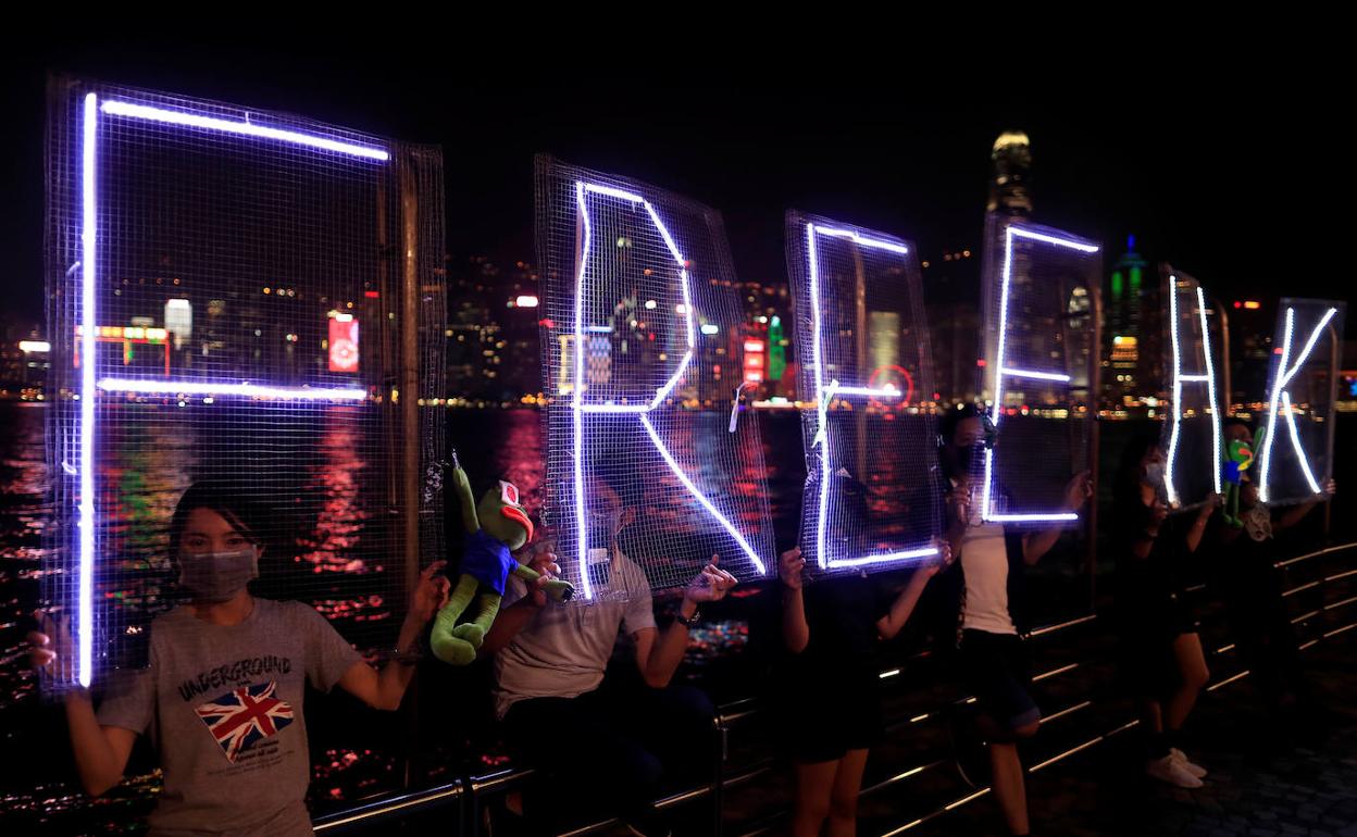 Cadena humana en el puerto de Hong Kong en el que piden 'Libertad' con letras luminiscentes.