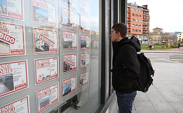 Un joven mira diferentes pisos en una inmobiliaria de Irun. 