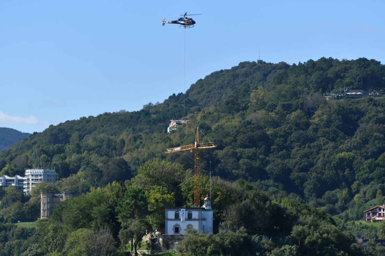 Un helicóptero ha sido el encargado de trasladar, por piezas, la grúa para la obra del Faro.