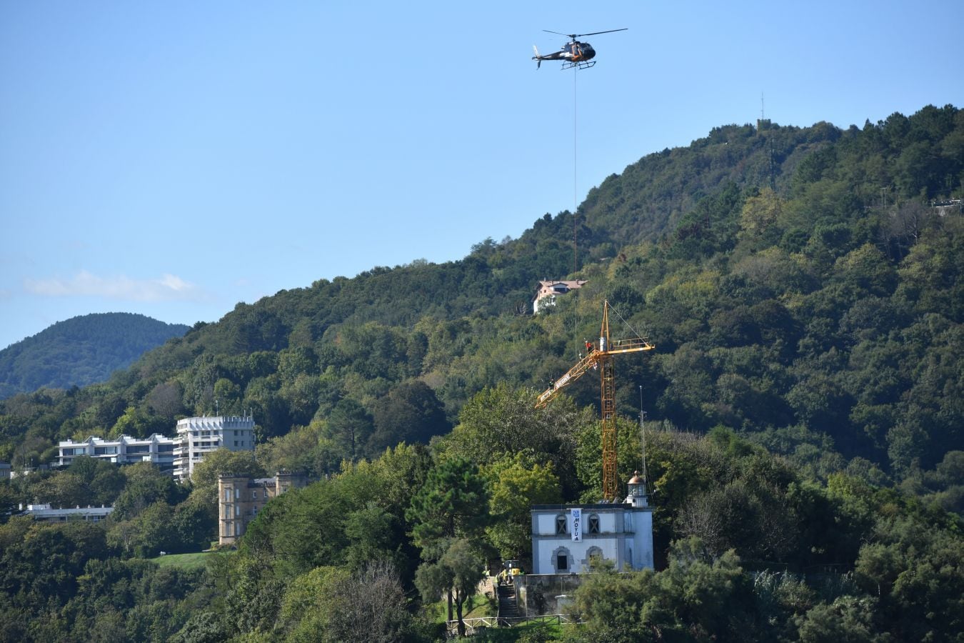 Un helicóptero ha sido el encargado de trasladar, por piezas, la grúa para la obra del Faro.