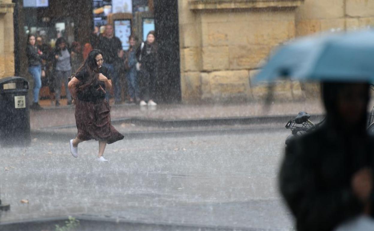 Una muher camina bajo la lluvia en San Sebastián.