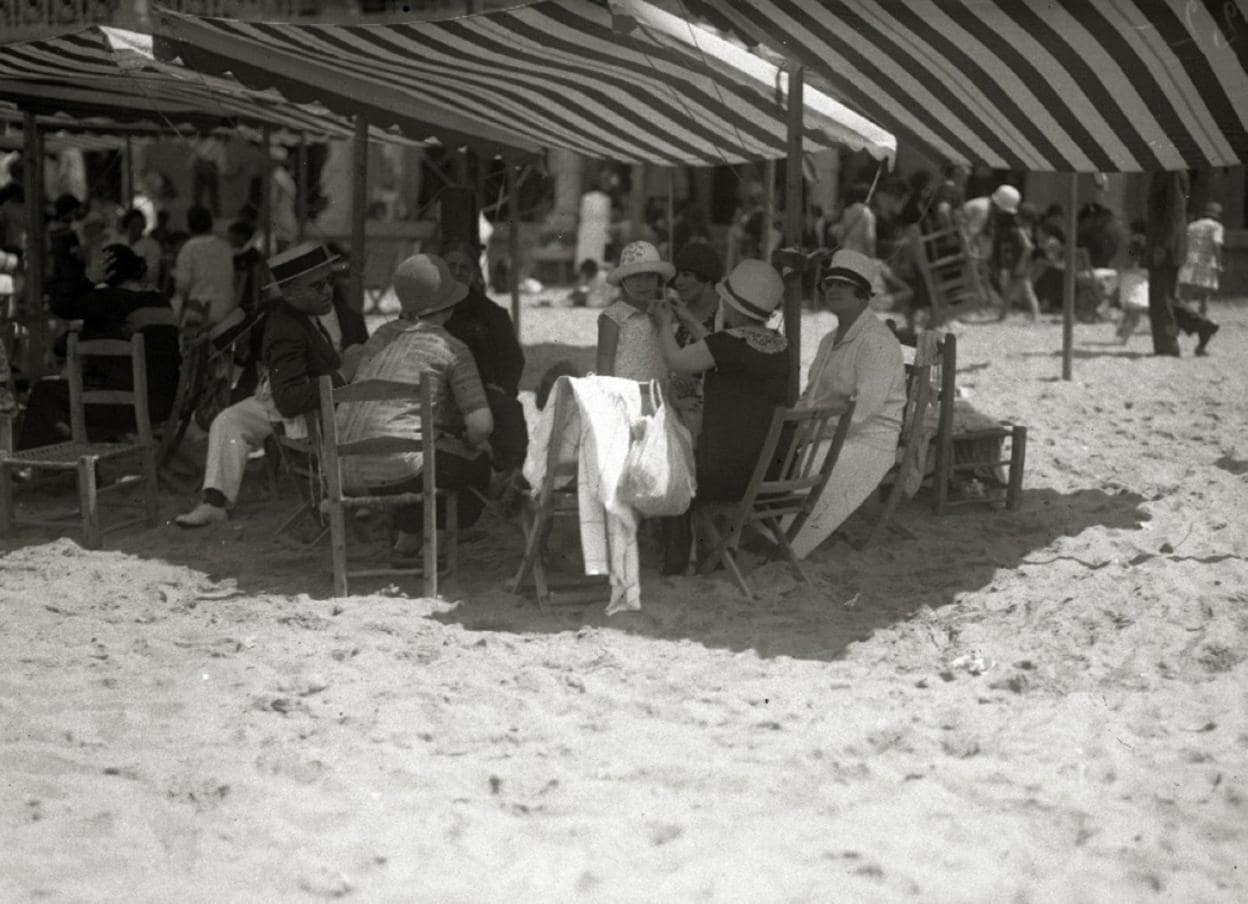 Grupo bajo un toldo en los años 20. Al fondo, las cabinas. 