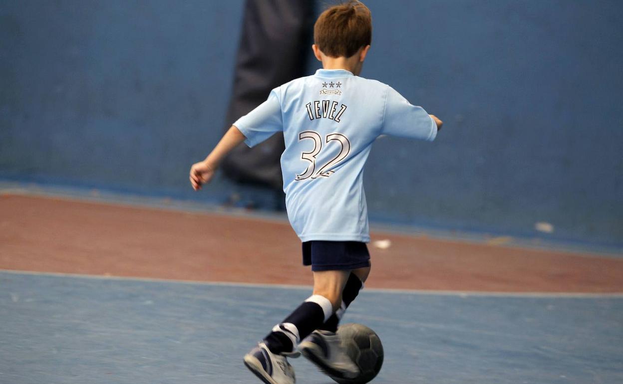 Un niño jugando a fútbol. 