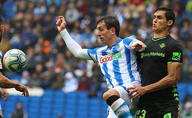 Mikel Oyarzabal trata de controlar un balón ante la presión de Aissa Mandi. 