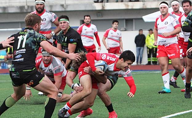 Aldanondo trata de seguir avanzando pese al placaje de un jugador del Bathco Santander. 