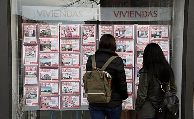 Dos jóvenes miran las ofertas de una inmobiliaria. 