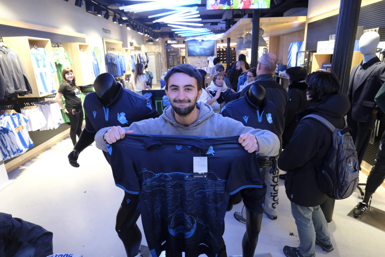 Cientos de aficionados realistas han esperado durante varias horas bajo la lluvia en las tiendas de la Real Sociedad para comprar una elástica