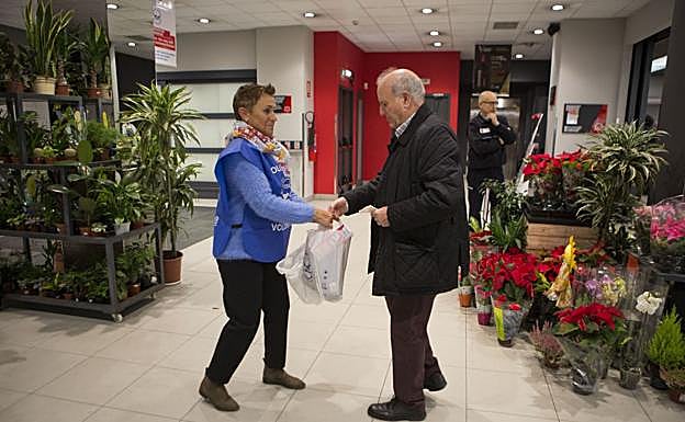 Un hombre recibe bolsas para hacer su compra solidaria en Irun.