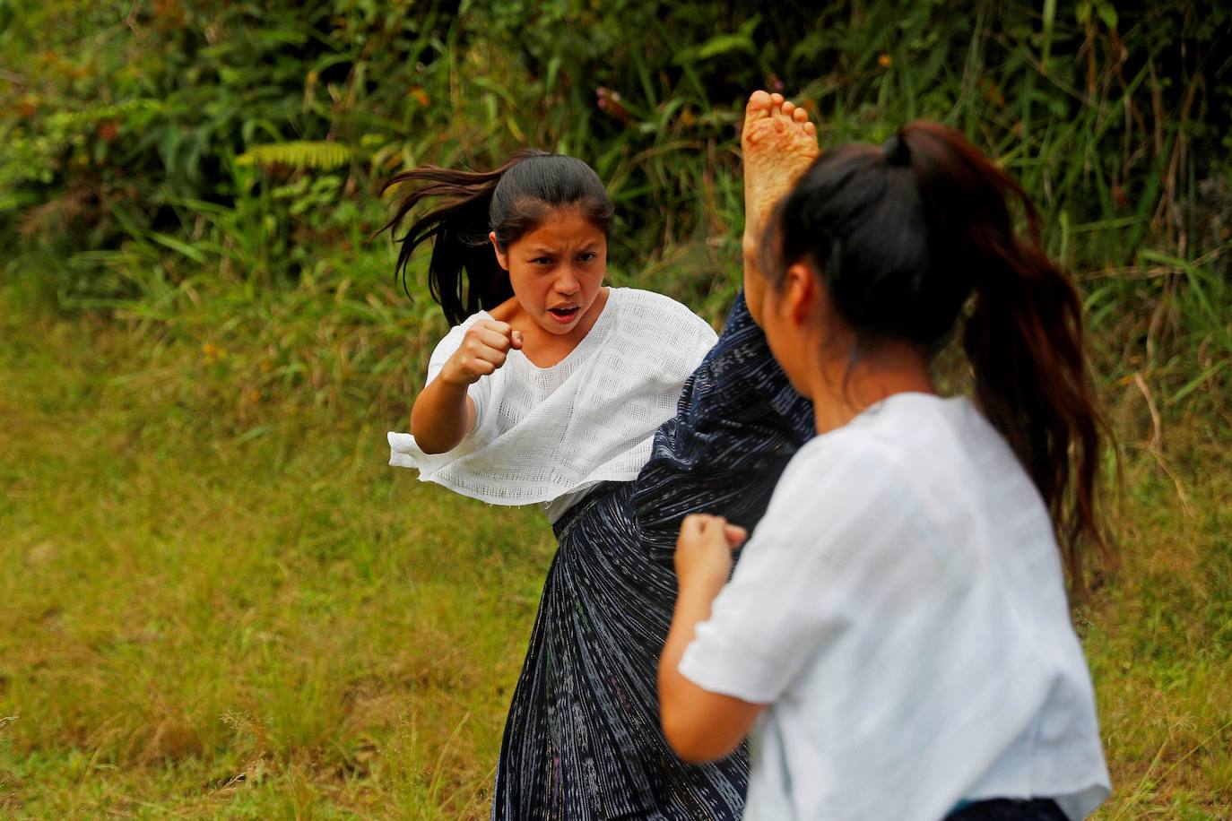 Niñas q'qchí de la aldea Tipulcan en San Pedro Carchá practican taekwondo con su maestro, Danny Coy, en una cancha de tierra en el medio de la aldea. Cada golpe es seguido por un fuerte grito que se resuena en las laderas de la zona montañosa de Alta Verapaz, en el norte de Guatemala. Con cada patada al aire, las niñas de la aldea Tipulcan espantan a los fantasmas de la violencia machista y el acoso que han sufrido en su comunidad. 