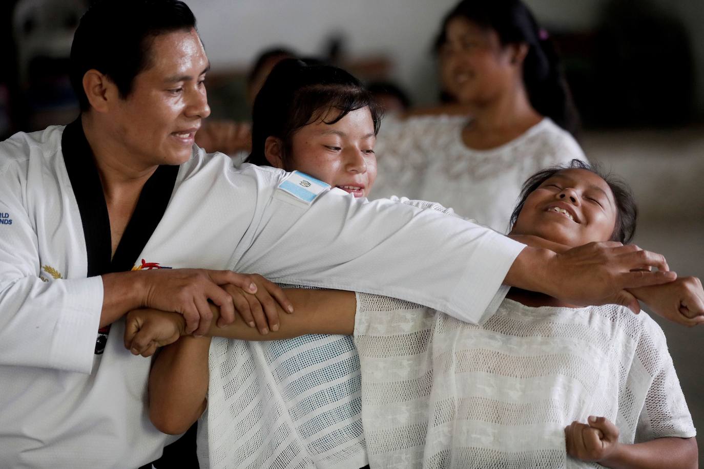 Niñas q'qchí de la aldea Tipulcan en San Pedro Carchá practican taekwondo con su maestro, Danny Coy, en una cancha de tierra en el medio de la aldea. Cada golpe es seguido por un fuerte grito que se resuena en las laderas de la zona montañosa de Alta Verapaz, en el norte de Guatemala. Con cada patada al aire, las niñas de la aldea Tipulcan espantan a los fantasmas de la violencia machista y el acoso que han sufrido en su comunidad. 
