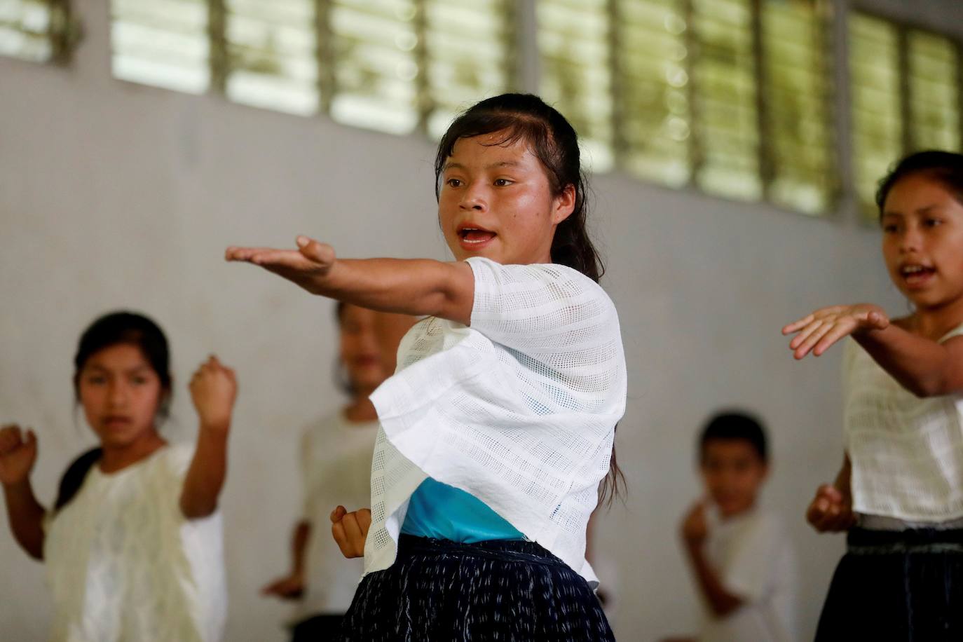 Niñas q'qchí de la aldea Tipulcan en San Pedro Carchá practican taekwondo con su maestro, Danny Coy, en una cancha de tierra en el medio de la aldea. Cada golpe es seguido por un fuerte grito que se resuena en las laderas de la zona montañosa de Alta Verapaz, en el norte de Guatemala. Con cada patada al aire, las niñas de la aldea Tipulcan espantan a los fantasmas de la violencia machista y el acoso que han sufrido en su comunidad. 