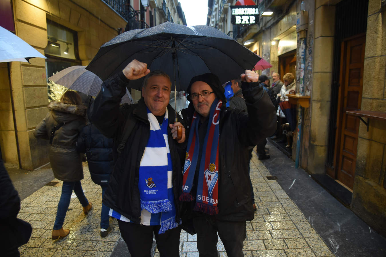 Seguidores de la Real Sociedad y Eibar han desafiado al mal tiempo y han teñido con sus colores la Parte Vieja donostiarra 