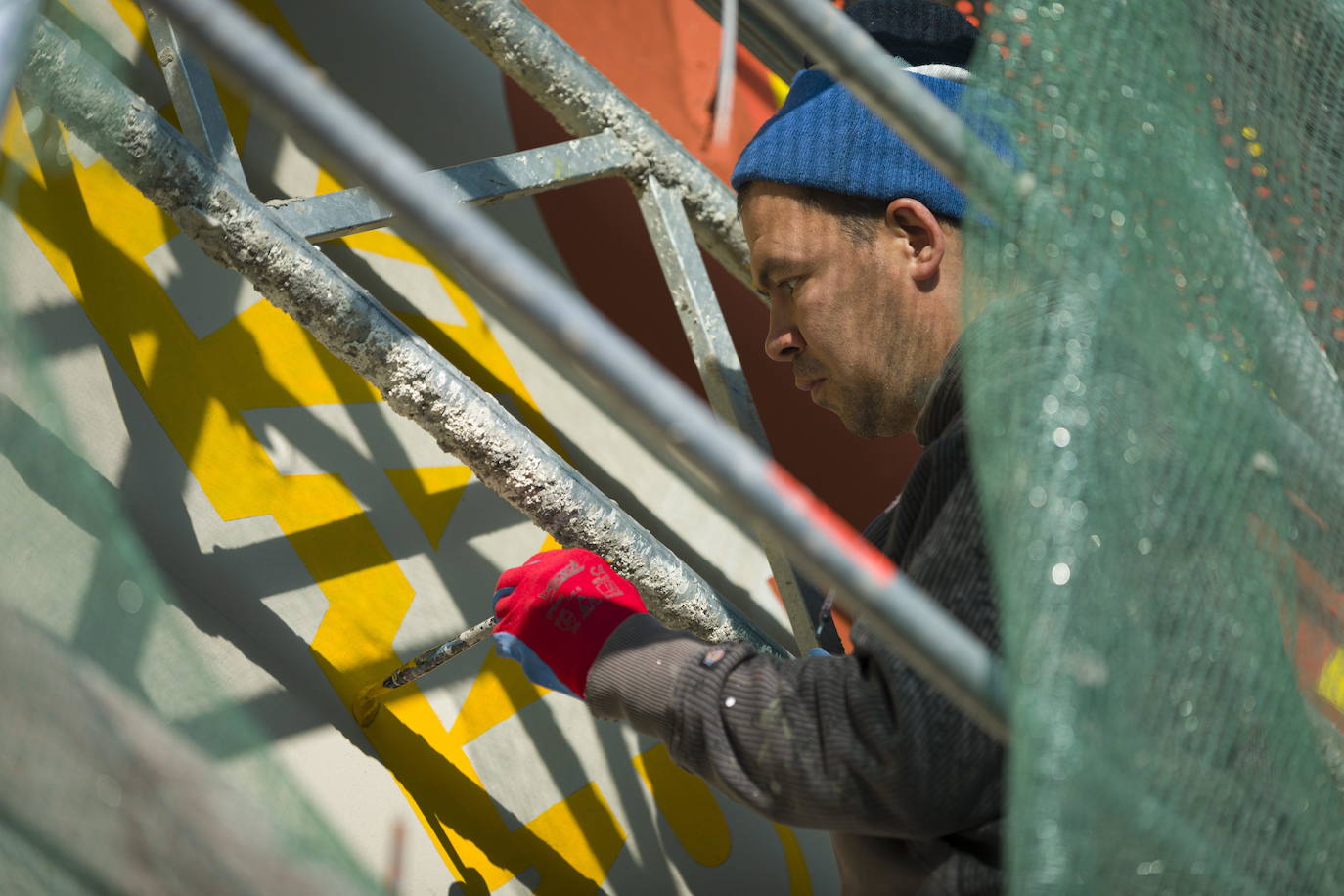Los miembros del grupo Szines Varos (ciudad colorida) trabajan en un andamio para crear un mural en un edificio residencial en el Distrito VIII de Budapest. La obra de arte de 600 metros cuadrados representa a los personajes principales de la popular caricatura húngara Macskafogo (lit. Cat Catcher) de 1986, que se distribuyó como 'cat city' en Estados Unidos. El colectivo artístico ha realizado muchos murales a gran escala en Budapest y otras ciudades húngaras, así como en Moscú, Berlín y Londres, desde su fundación en 2008.