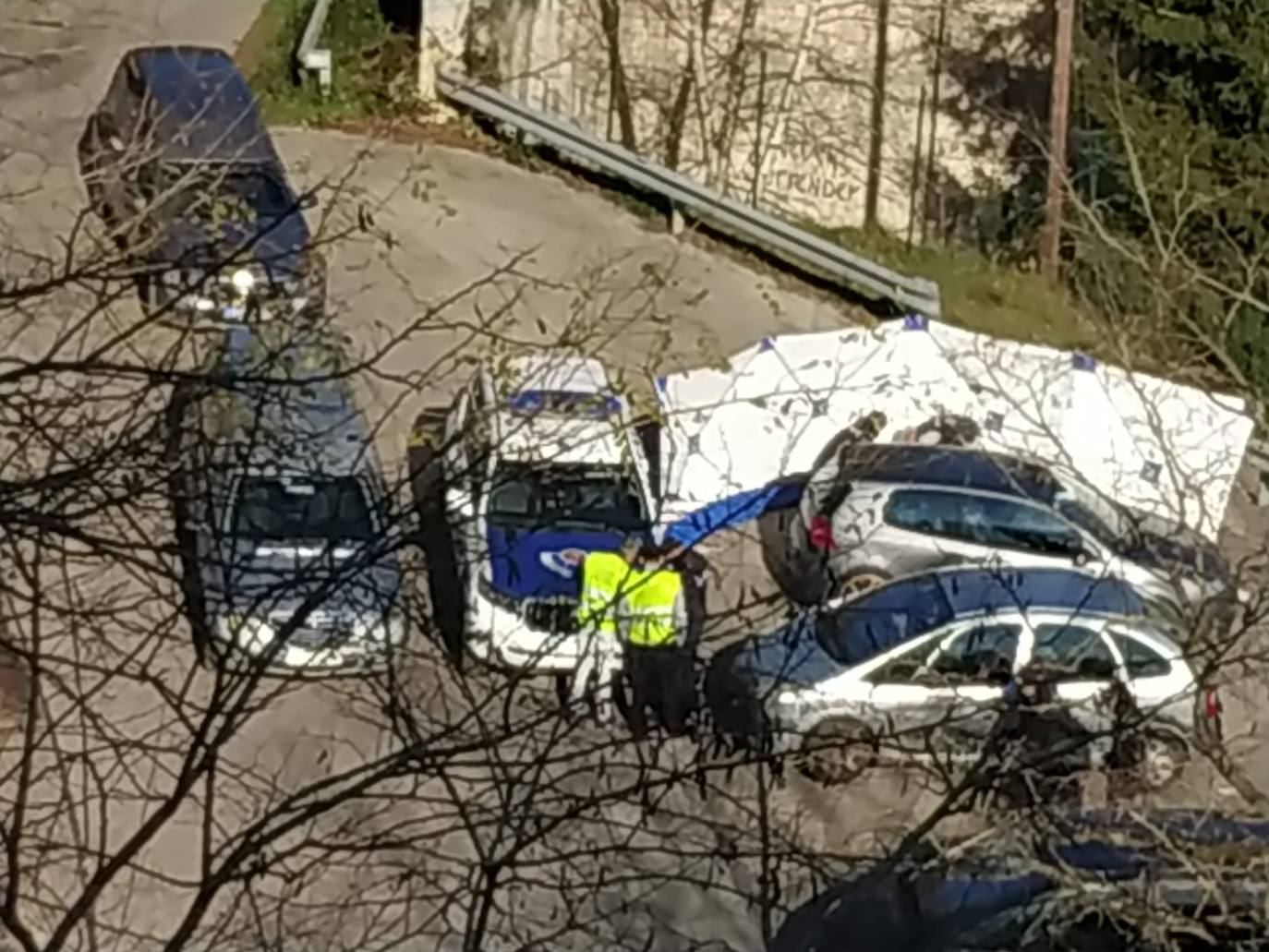 Agentes de la Ertzaintza inspeccionan el lugar donde estaba el vehículo en el que han sido hallados los cuerpos de los dos jóvenes
