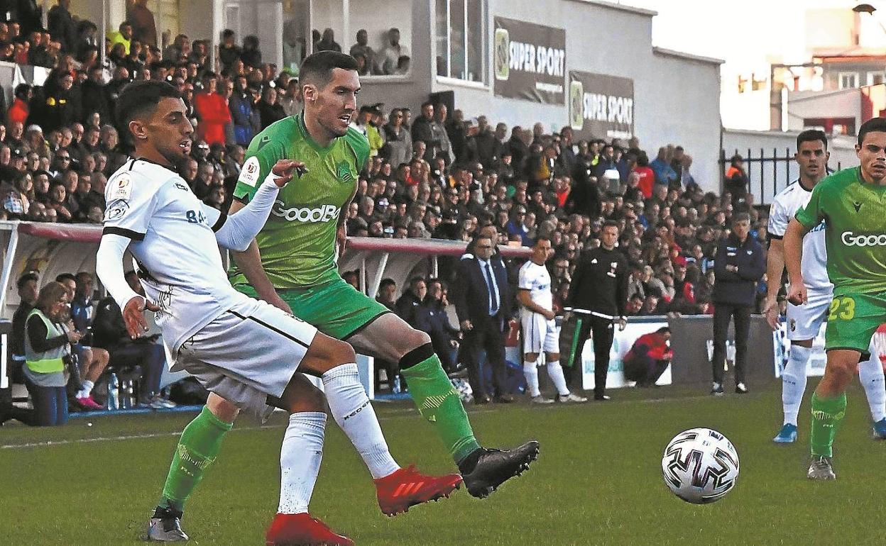 Zaldua trata de cortar un pase de un jugador del Ceuta ante la presencia de Sangalli y de Imanol en el área técnica. 