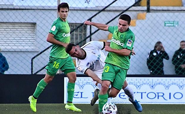 Sangalli salva una entrada de un jugador ceutí ante la presencia de su compañero de la Real Sociedad Guevara