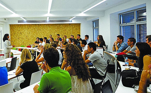 Alumnos atienden a una profesora durante una charla