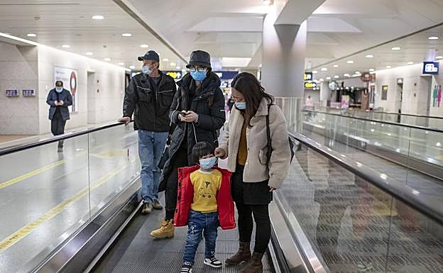 Una familia china llega al aeropuerto de Shanghái con las mascarillas de protección puestas. 